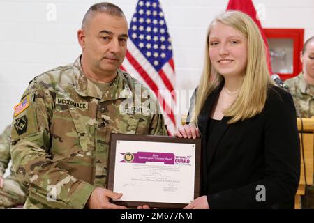 Lily Palfrey, à droite, fille du Sgt. Frank Palfrey, 1st ans, reçoit le Prix des jeunes volontaires 2020 du Bureau de la Garde nationale du général Mark McCormack, commandant de la Division d'infanterie 28th, lors d'une cérémonie à l'arsenal de la Brigade expéditionnaire de l'aviation de combat 28th. Lily a été nommée lauréate du prix au début de 2021, tandis que son père a été déployé avec l'ECAB 28th. Elle voulait attendre que son père soit à la maison pour recevoir le prix. 1st le Sgt Palfrey est le chef principal inscrit de la Compagnie du siège social et du siège social, 28th ECAB. Banque D'Images