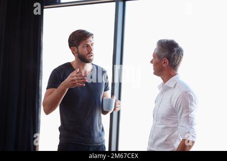 Nous devons aller sur la même page. deux beaux hommes d'affaires ayant une discussion dans le bureau. Banque D'Images