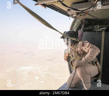 ZARQA, Jordanie – le chef d'équipage des Forces armées royales jordaniennes UH-60 Black Hawk surveille la zone de chute lors d'un saut combiné avec les forces spéciales américaines dans le Royaume hachémite de Jordanie. Banque D'Images