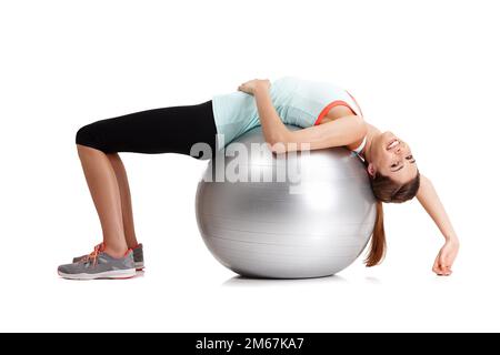 Si cela ne vous défie pas, cela ne vous change pas. une jeune femme en forme s'exerçant avec son ballon d'exercice isolé sur blanc. Banque D'Images