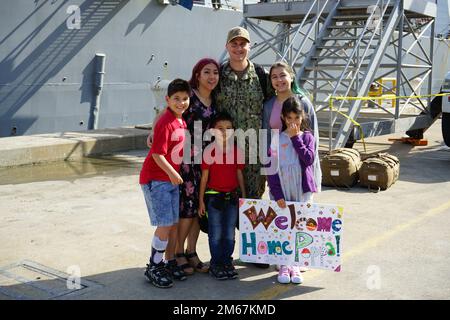 220413-N-DT940-1091 NORFOLK, VIRGINIE (13 avril 2022) Un marin affecté au destroyer de missile guidé de classe Arleigh Burke USS Forrest Sherman (DDG 98) pose pour une photo avec sa famille après le retour du navire à son port d'attache, à la station navale de Norfolk (13 avril). Forrest Sherman s'est déployé sur le théâtre d'opérations européen et a participé à une série d'activités maritimes à l'appui des forces navales en Europe et des alliés de l'OTAN. Banque D'Images