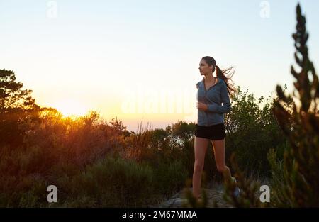 Courez la journée, ne vous laissez pas courir. une jeune femme qui fait du jogging à l'extérieur. Banque D'Images