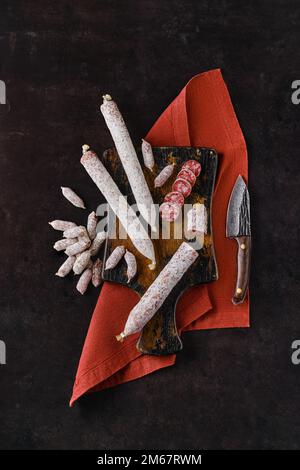 Composition verticale avec saucisses salami fermentées sur planche à découper en bois Banque D'Images