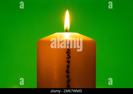 Bougie avec calendrier de l'Avent sur fond vert chroma clé traditionnel brûlant Noël bougies cirées avec les chiffres compte à rebours pour Noël. Bel Avent à la maison. Éclairage de Noël et arrière-plan sombre. La veille de Noël Banque D'Images