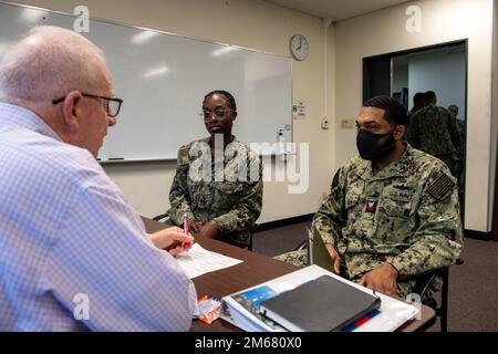 SASEBO, Japon (14 avril 2022) Airman Aryanna Coker, au centre, de Phoenix, et Culinary Specialist 1st Class Clyde Scott, à droite, de Hitchcock, Texas, tous deux affectés au navire d'assaut amphibie déployé vers l'avant USS America (LHA 6), parlent à l'ancien maître Petty Officer Randy Miller, de Kansas City, au Missouri, À propos des qualifications de Coker pour la notation de Spécialiste de la vente au détail lors d'un rodéo professionnel d'apprentissage organisé par l'équipe d'engagement de la flotte du Commandement du personnel de la Marine à la chapelle de base à bord des États-Unis Activités de la flotte Sasebo. L'équipe chargée de l'engagement du parc NPC a voyagé de Millingt Banque D'Images