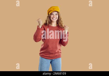 Portrait d'une femme heureuse et excitée avec des poings serrés qui applaudissent pour quelqu'un ou se réjouissent de la réussite. Banque D'Images