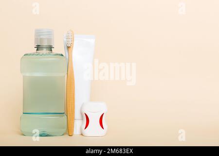 Bain de bouche et autres produits d'hygiène bucco-dentaire sur une table colorée avec espace pour les copies. Pose à plat. Hygiène dentaire. Produits d'hygiène bucco-dentaire et espace pour le texte o Banque D'Images