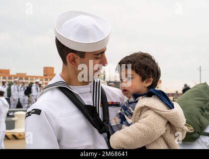 NORFOLK (16 avril 2022) - Un marin affecté au destroyer à missiles guidés de classe Arleigh Burke USS Mitscher (DDG 57), embrasse son fils après le retour du navire à homeport, à la station navale de Norfolk, 16 avril. Mitscher s'est déployé sur le théâtre d'opérations européen et a participé à toute une série d'activités maritimes à l'appui des forces navales en Europe et des alliés de l'OTAN. Banque D'Images