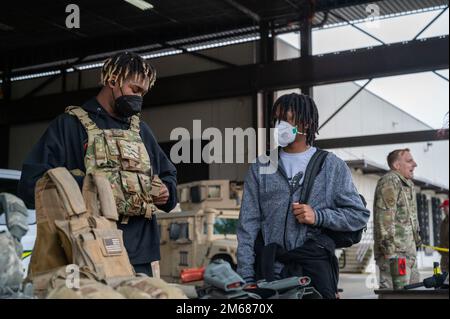 Les membres du Programme des jeunes de la Red-Twn Hawks essaient de l'équipement des forces de sécurité lors de l'événement de l'aile inspiration et mentorat en aviation (AIM) à la base conjointe Lewis-McChord, Washington, 16 avril 2022. L’escadre AIM est un programme de sensibilisation communautaire dont la mission est d’informer, d’influencer et d’inspirer la prochaine génération d’aviateurs de la Force aérienne. Banque D'Images