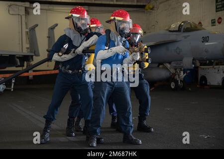 Les marins affectés au service aérien de l’USS Gerald R. Ford (CVN 78) simulent la lutte contre un incendie lors d’un exercice de quartier général dans la baie hangar, en 16 avril 2022. Ford est en cours dans l'océan Atlantique en menant des qualifications de transporteur et en intégrant des groupes de grève avant le déploiement opérationnel. Banque D'Images