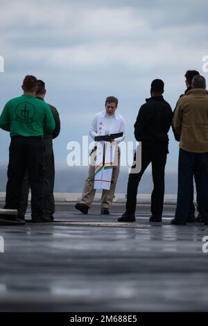 USS Gerald R. Ford (CVN 78) et Carrier Strike Group 12 Aumônier Cmdr. Geneviève Clark, de McMinnville, Oregon, préside le service de lever du soleil du dimanche de Pâques sur le pont de vol, 17 avril 2022. Ford est en cours dans l’océan Atlantique en menant des qualifications de transporteur et l’intégration du groupe de grève dans le cadre de la phase de base sur mesure du navire avant le déploiement opérationnel. Banque D'Images