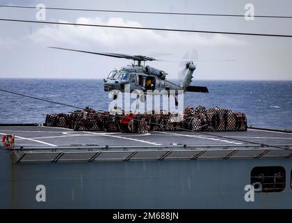 220417-N-UD000-1120 OCÉAN ATLANTIQUE (17 avril 2022) un hélicoptère MH-60s Sea Hawk, attaché à l'Escadron de combat de la mer (HSC) 7, récupère des fournitures au porte-avions USS George H.W. Bush (CVN 77) lors d'une reconstitution verticale avec le navire de cargaison sèche USNS William McLean (T-AKE 12), 4 mars 2022. George H.W. Bush fournit à l'autorité de commandement nationale une capacité de combat flexible et tailleurs par le biais du groupe de grève des transporteurs qui maintient la stabilité et la sécurité maritimes afin d'assurer l'accès, de décourager l'agression et de défendre les intérêts américains, alliés et partenaires. Banque D'Images