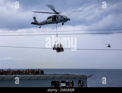 220417-N-UD000-1149 OCÉAN ATLANTIQUE (17 avril 2022) un hélicoptère MH-60s Sea Hawk, attaché à l'Escadron de combat de la mer (HSC) 7, récupère des fournitures au porte-avions USS George H.W. Bush (CVN 77) lors d'une reconstitution verticale avec le navire de cargaison sèche USNS William McLean (T-AKE 12), 4 mars 2022. George H.W. Bush fournit à l'autorité de commandement nationale une capacité de combat flexible et tailleurs par le biais du groupe de grève des transporteurs qui maintient la stabilité et la sécurité maritimes afin d'assurer l'accès, de décourager l'agression et de défendre les intérêts américains, alliés et partenaires. Banque D'Images