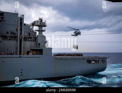 220417-N-UD000-1145 OCÉAN ATLANTIQUE (17 avril 2022) un hélicoptère MH-60s Sea Hawk, attaché à l'Escadron de combat de la mer (HSC) 7, récupère des fournitures au porte-avions USS George H.W. Bush (CVN 77) lors d'une reconstitution verticale avec le navire de cargaison sèche USNS William McLean (T-AKE 12), 4 mars 2022. George H.W. Bush fournit à l'autorité de commandement nationale une capacité de combat flexible et tailleurs par le biais du groupe de grève des transporteurs qui maintient la stabilité et la sécurité maritimes afin d'assurer l'accès, de décourager l'agression et de défendre les intérêts américains, alliés et partenaires. Banque D'Images