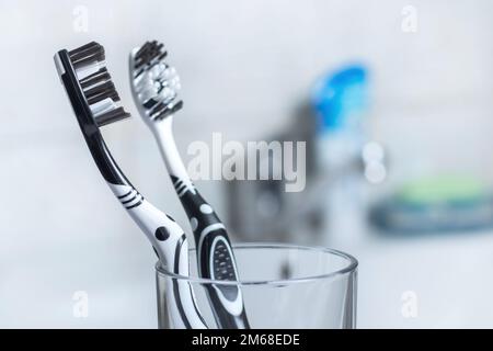 Les brosses à dents dans un verre avec espace copie dans la salle de bains. Banque D'Images