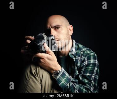 Un photographe masculin tenant un appareil photo reflex d'époque Banque D'Images