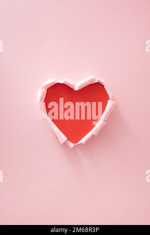 Cœur rouge en papier rose déchiré. Un minimum d'amour ou de valentine concept. Banque D'Images