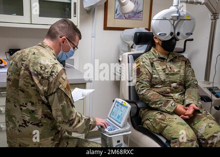 Le capitaine Dominic Rentz, optométriste de l'escadron de préparation médicale opérationnelle 15th, effectue un examen oculaire sur le 1st lieutenant Denise Guiao-Corpuz, chef des affaires publiques de la 15th e Escadre, à la base conjointe Pearl Harbour-Hickam, à Hawaï (19 avril 2022). Les examens oculaires aident à documenter les yeux en enregistrant la santé et les changements tout au long des années. Banque D'Images