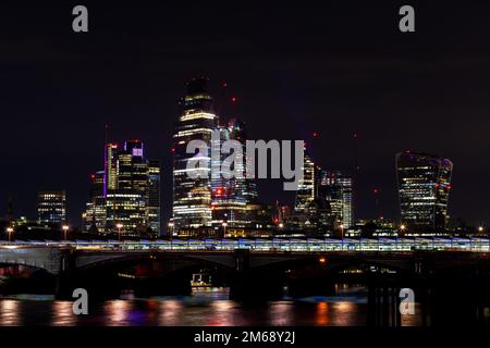 Vue magnifique sur le paysage de la ville de Londres depuis le front de mer de la Tamise la nuit, prise de vue à main levée. Concept de croissance rapide et de développement urbain. Banque D'Images
