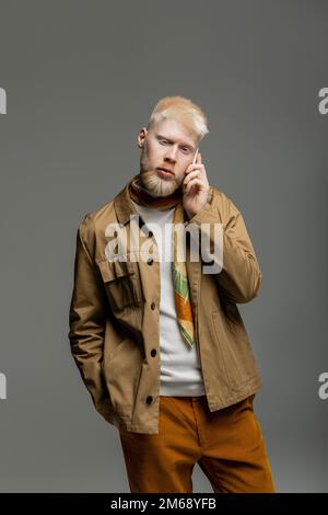 albinos barbu dans une élégante veste de chemise parlant sur smartphone isolé sur gris, image de stock Banque D'Images