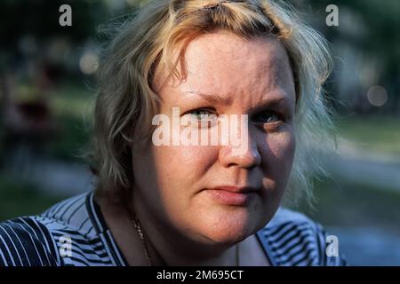 Lac Uvildy, région de Chelyabinsk, Russie - 09 juillet 2019. Le visage d'une belle femme est illuminé par les rayons du soleil, gros plan. Banque D'Images