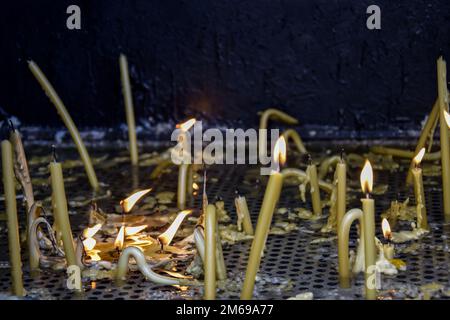 Bougies allumées dans l'église. Bougies allumées sur fond sombre. Copier l'espace. Faible profondeur de champ. Banque D'Images