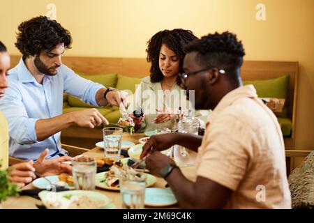 Groupe de quatre amis qui déjeunent dans un restaurant. Concept de réunion et de célébration. Banque D'Images