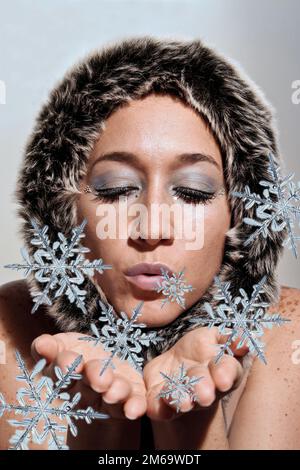 Belle femme soufflant de neige Banque D'Images