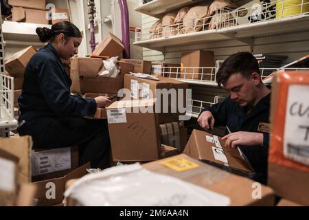 LE marin Maria Ochoa, spécialiste de la logistique DE LA MER DES PHILIPPINES (21 avril 2022), à gauche, de Los Angeles, et le spécialiste de la logistique 3rd, classe John Pattinson, de Minette, en Alabama, effectuent un inventaire à bord du porte-avions USS Abraham Lincoln (CVN 72) de la classe Nimitz. Abraham Lincoln Strike Group est en cours de déploiement prévu dans la zone d'exploitation de la flotte américaine 7th afin d'améliorer l'interopérabilité par le biais d'alliances et de partenariats tout en servant de force de réaction prête à l'emploi pour soutenir une région libre et ouverte d'Indo-Pacifique. Banque D'Images