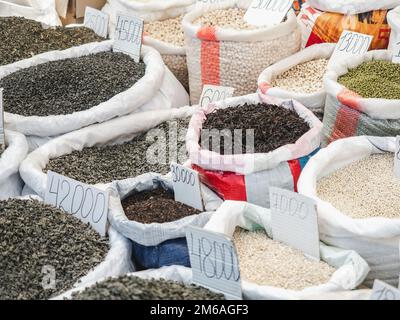 Sacs et bols aux épices parfumées au marché par temps ensoleillé et clair. Gros plan, plein air, pas de personne. Concept de nourriture savoureuse et saine Banque D'Images