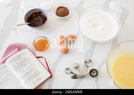 Cuisson des ingrédients et livre de recettes sur un comptoir blanc Banque D'Images