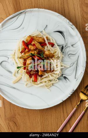 nouilles de riz asiatiques avec poulet dans une sauce chaude Banque D'Images