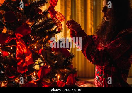femme décorant l'arbre de noël à la maison Banque D'Images