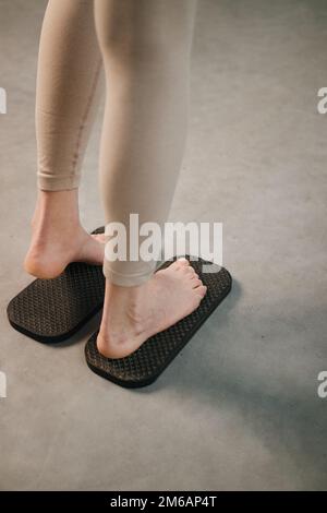 La femme se tient sur un panneau en bois avec des clous métalliques pointus sadhu yoga board Banque D'Images