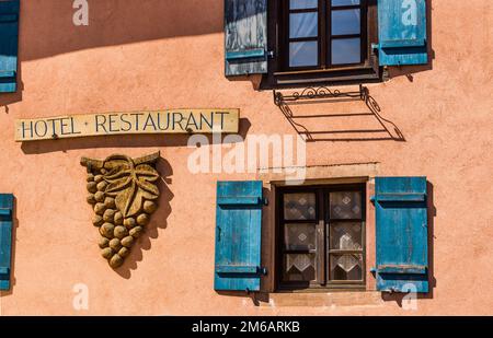 Façade de l'hôtel avec volets bleus, raisin en bois Banque D'Images