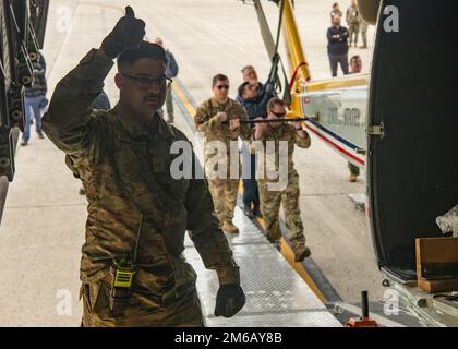 Le principal Airman Laramie Hutcheson, compagnon de services aux passagers affecté à l'escadron du port aérien 89th, donne les pouces pour charger un hélicoptère UH-1N Iroquois huey sur un C-17 sur la ligne de floightline à la base interarmées Andrews, Maryland, avril. 21, 2021. Hutcheson et d'autres ports dawgs ont aidé l'Escadron d'hélicoptères 1st à évaluer comment rendre son Huey plus mobile pour les opérations de mobilité rapide tout en utilisant l'événement pour améliorer l'expérience de formation de ses nouveaux avions. Banque D'Images