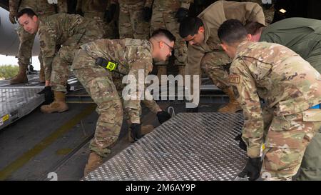 Des aviateurs affectés à l'escadron du port aérien 89th ont mis des rampes en place pour aider à charger un hélicoptère UH-1N Iroquois Huey sur la ligne aérienne à la base interarmées Andrews, au Maryland, en avril. 21, 2021. Supervisant l'un des ports les plus achalandés de la Force aérienne, le SPB de 89th fournit un soutien continu au transport aérien au président, au vice-président, aux membres du cabinet, aux commandants des combattants et à d'autres hauts responsables militaires et aux dirigeants élus pour les opérations de la Mission aérienne spéciale (SAM). Banque D'Images