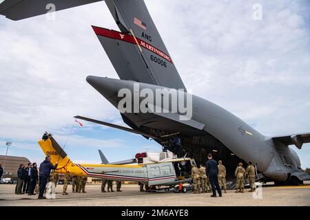 Des aviateurs affectés au 89th Escadron de port aérien, au 316th Escadron de préparation à la logistique et au 1st Escadron d'hélicoptères, ainsi que des gardes nationaux de l'Air de Virginie-Occidentale du 167th Escadron de transport aérien, tentent de charger un hélicoptère UH-1N Iroquois huey sur un C-17 sur la ligne de vol à la base interarmées Andrews, Maryland, avril. 21, 2021. Les quatre unités participent à un exercice de chargement (LOADEX), qui permet aux membres du ministère de la Défense de mettre en pratique une variété de scénarios impliquant le transport d'équipement, de fournitures et de véhicules militaires tout en notant ce qui fonctionne et ce qui pourrait changer pour faire l Banque D'Images