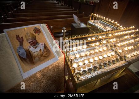 Une image du pape émérite Benoît XVI à côté de bougies allumées à l’église Sainte Marie de Belfast, en Irlande du Nord. Benoît, 95 ans, est mort samedi après 10 ans dans une retraite papale extraordinaire vécu dans un monastère dans les jardins du Vatican. Date de la photo: Mardi 3 janvier 2023. Banque D'Images