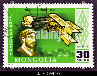 Timbre-poste annulé imprimé par la Mongolie, qui montre Henry Farman et son avion (1909), 75th anniversaire du premier vol motorisé, vers 1978. Banque D'Images