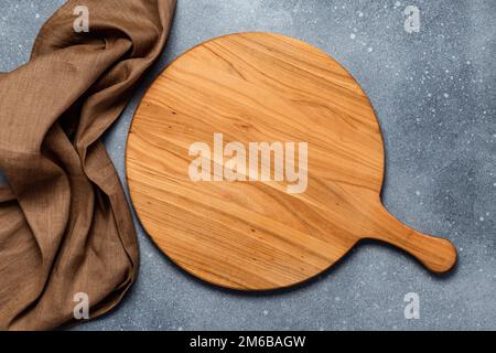 Table de service ronde en bois vide avec poignée sur fond de béton gris ancien, table en sorbde. Vue de dessus. Modèle alimentaire avec espace de copie. Plat Banque D'Images