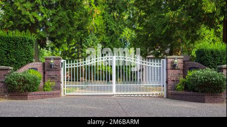 Double porte en fer forgé. Porte en fer forgé et pilier en pierre. Portes d'entrée en fer forgé blanc de la propriété rurale Banque D'Images