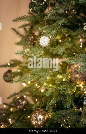 Anciennes horloges rétro vintage, boules d'or accrochent sur la branche de fond vert arbre de Noël. Épinette, sapin, pin feux du nouvel an, guirlande floue, Banque D'Images