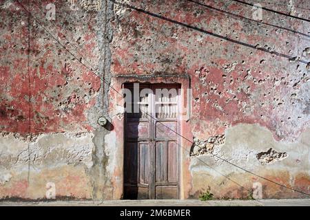 Ancienne porte en bois et mur en pierre rose à Valladolid, Yucatan, Mexique Banque D'Images