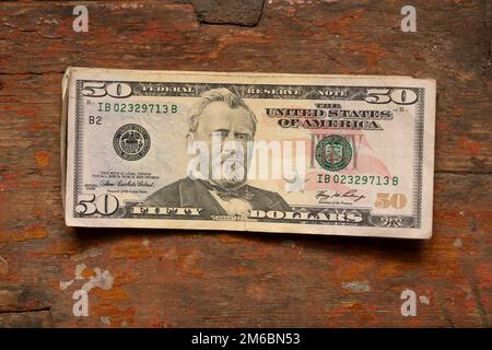50 dollars se trouvent sur une vieille table en bois, thème financier Banque D'Images