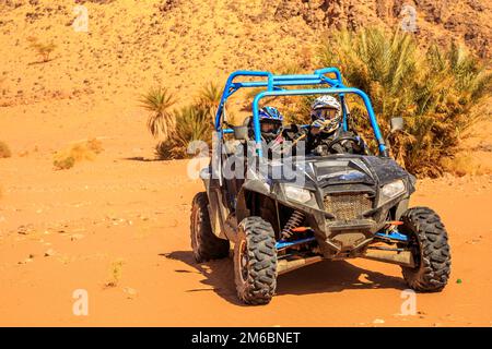 Merzouga, Maroc - 26 févr. 2016: Vue de face sur le bleu Polaris RZR 800 avec ses pilotes dans le désert marocain près de Merzouga. Merzouga Banque D'Images