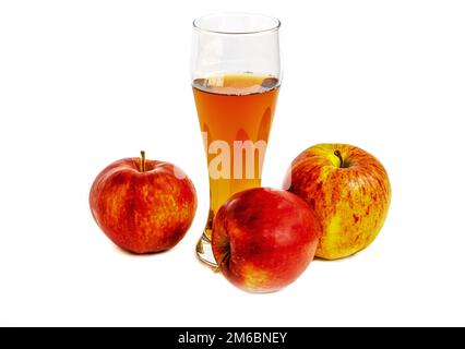 Trois pommes mûres et un verre de jus de pomme sur fond blanc Banque D'Images