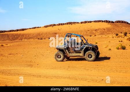 Merzouga, Maroc - 26 févr. 2016: Vue latérale sur le bleu Polaris RZR 800 avec ses pilotes dans le désert marocain près de Merzouga. Merzouga i Banque D'Images