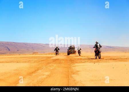 Merzouga, Maroc - février 22 2016 : convoi de véhicules tout-terrain (4x4 et motos) dans le désert marocain près de Merzouga. Merzouga est f Banque D'Images