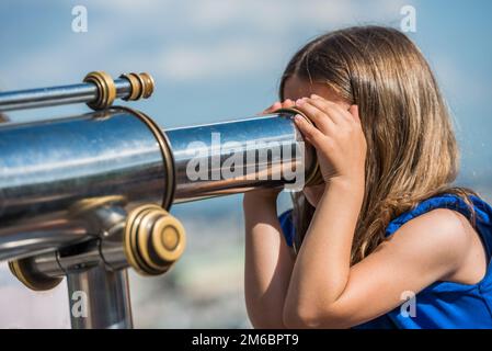 Paris, France- 30 juin 2013: Petite fille regardant à travers les jumelles touristiques monuments de paris Banque D'Images